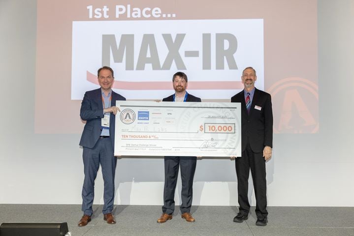 Three men holding a large check